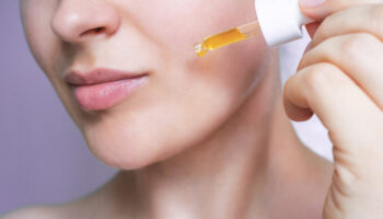 Woman Applying Serum with Dropper on Skin for Professional-Grade Skincare Routine