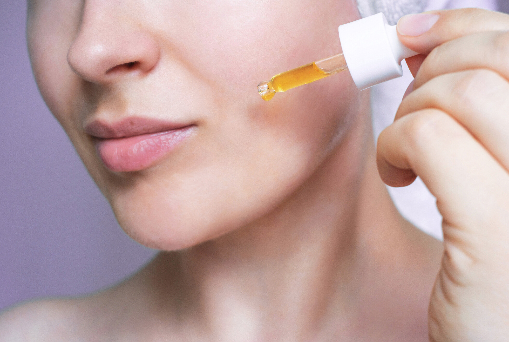 Woman Applying Serum with Dropper on Skin for Professional-Grade Skincare Routine