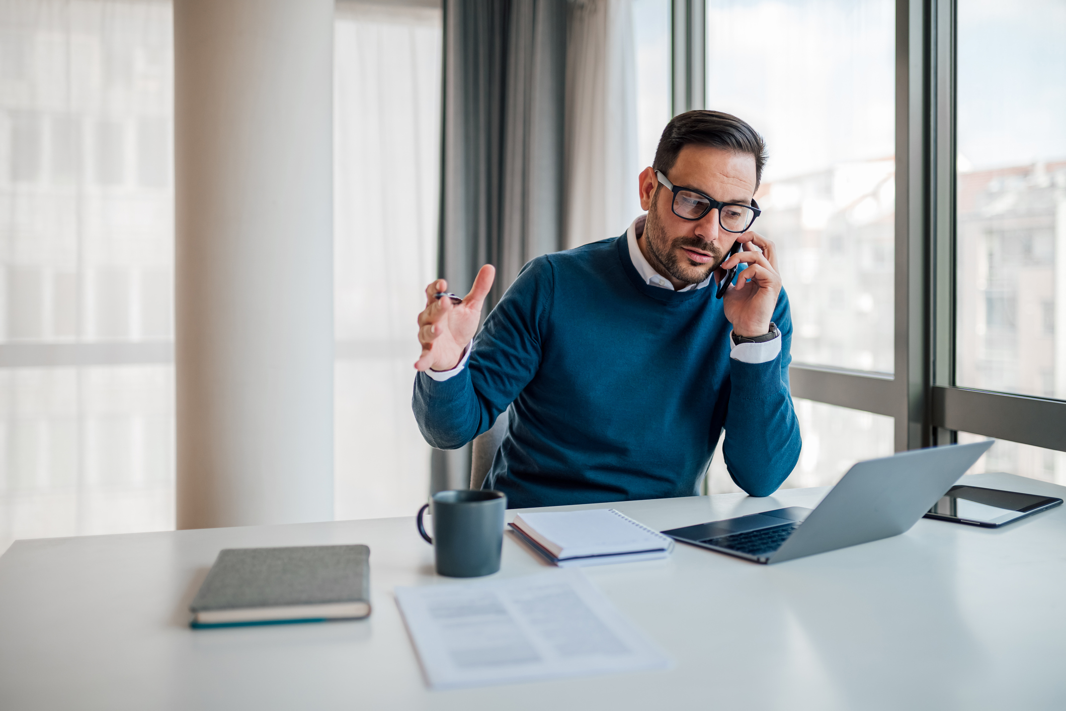 A burnt out aesthetic sales rep on the phone in a high-rise office
